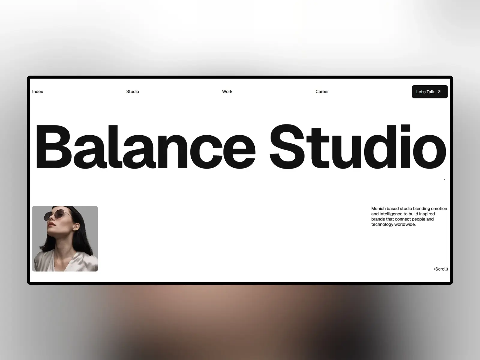 Minimalist webpage design for 'Balance Studio' with bold text. Features a monochrome photo of a person wearing sunglasses in the bottom left.