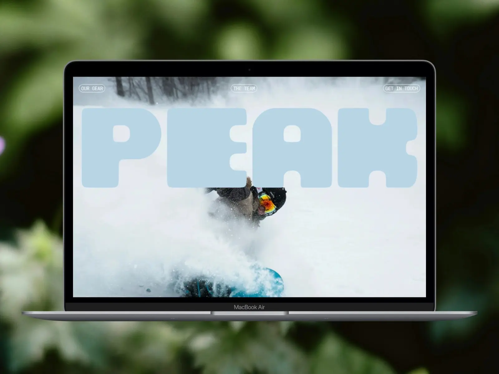 Laptop displaying an image of a snowboarder in action, surrounded by snow, with the word 
